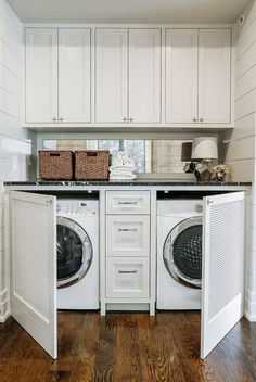 a white washer and dryer in a room with wooden floors, cabinets and drawers