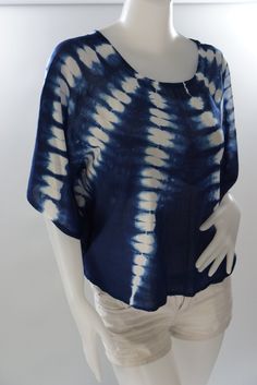 a white mannequin wearing a blue and white tie - dyed top with short sleeves