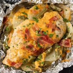 chicken covered in cheese and vegetables on foil