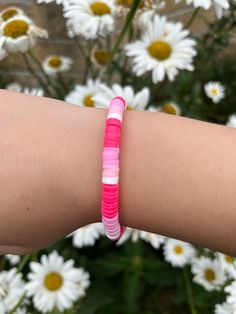 a woman's arm with a pink and white bracelet on it