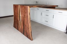 a kitchen counter made out of wood and white cabinets