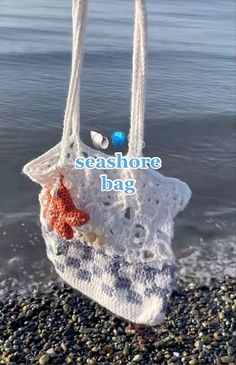 a handbag is hanging from a rope on the beach with words seashore bag