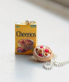 a box of cheerios next to a necklace on a table