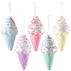 four ice cream cones with sprinkles hanging from strings on a white background