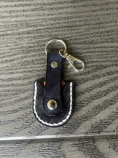 a black leather keychain with white stitching