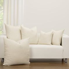 a white couch sitting on top of a hard wood floor