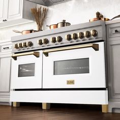 a white stove top oven sitting inside of a kitchen next to wooden floors and cabinets