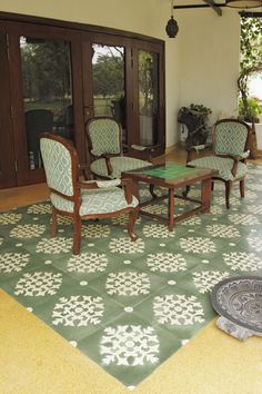 a living room filled with furniture and a green table on top of a tiled floor