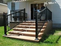 a set of stairs leading up to the front door of a house with metal railings