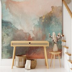 a table and two stools in front of a wall with a painting on it