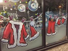 the window is decorated with christmas stockings and santa's stocking hanging on a line