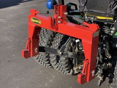 the front end of a tractor that is parked in a parking lot with it's tires