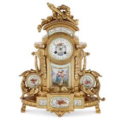 an ornate gold clock with paintings on the front and sides, sitting against a white background