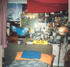 there is a bed in the room with many pictures on the wall behind it and a number plate that reads bs 50