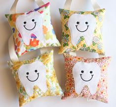 four pillows with different designs on them, one has a tooth and the other has a flowered design