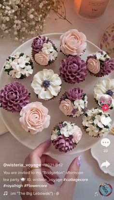 cupcakes decorated with pink and white flowers on a plate