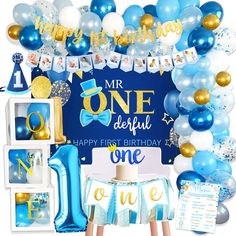 a blue and gold first birthday party with balloons, streamers, decorations and cake