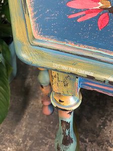 an old painted table with flowers on it