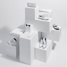 several white boxes with shoes on them in the shape of squares and rectangles