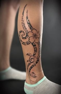 a woman's leg with a tattoo on it and flowers in the middle of her legs