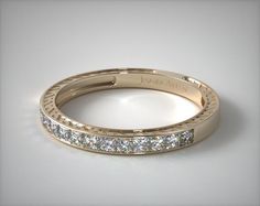 an 18k yellow gold wedding band with princess cut diamonds set in the center and sides