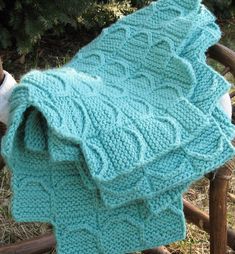 a knitted blanket sitting on top of a wooden chair