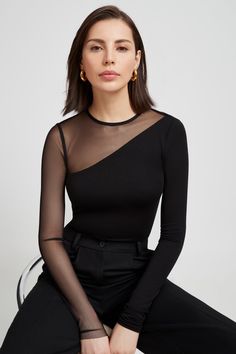 Our Milo Top drips minimalism with an edge. European jersey meets European mesh in a stunning asymmetric piece with a round neck and one full mesh sleeve for an elevated show of skin. The contrast of the classic and the unexpected will leave you looking and feeling ready for anything - day to night, casual to elegant.[SPLIT] Julia, in black, is 5'10" (178 cm) tall, wearing size XS. Astrid is 5'9" (175 cm) tall, wearing size XS. Total length is approximately 26" (66 cm). Sustainable European Jers Lycra Tops For Women, Body Elegante, Modern Workwear, Contemporary Loft, Outfit Elegantes, Sheer Tops, Look Formal, Black Mesh Top, Contemporary Clothing