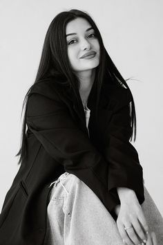 a black and white photo of a woman sitting down