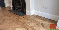 an empty living room with wood flooring and a fire place