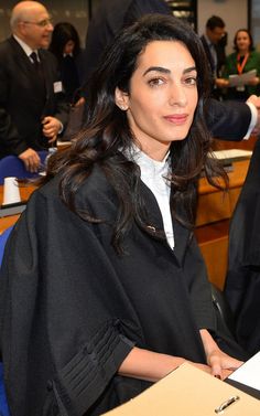 a woman sitting at a table in front of a judge's box and other people