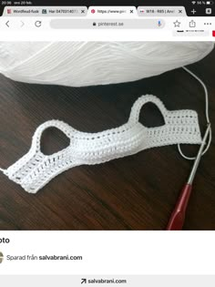 a white crocheted object sitting on top of a table next to a pair of scissors