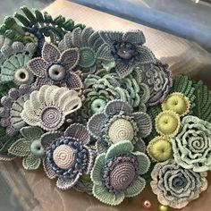 crocheted flowers are sitting on top of a piece of paper with beading