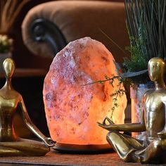 a large rock sitting on top of a wooden table next to two small figurines