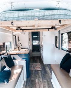 the interior of a camper with couches and kitchen area in it, including a bed