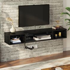 a flat screen tv mounted to the side of a brick wall in a living room