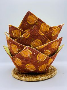 an orange and yellow patterned bowl sitting on top of a wicker basket