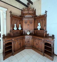 an ornate wooden cabinet with vases on it's sides and shelves in the middle