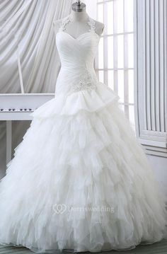 a white wedding dress on display in front of a window