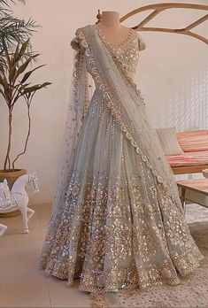 a mannequin is dressed up in a silver lehenga with gold sequins