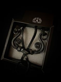 an open box with a black ribbon in it