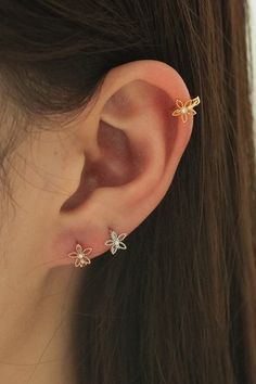 a close up of a person's ear with three small flowers on it