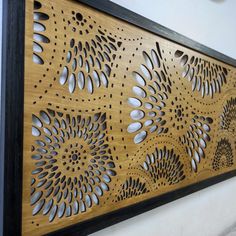 an intricate laser cut wood panel is mounted on the wall