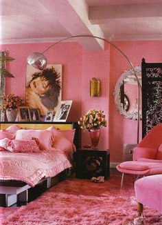 a bedroom with pink walls and rugs on the floor