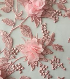 some pink flowers and leaves on a light blue background with gold foiled sequins