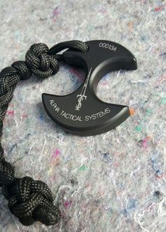 a black and white rope with an umbrella hook attached to it on a gray surface