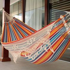 an orange and blue striped hammock sitting in front of a building