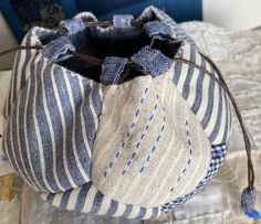 a blue and white striped bag sitting on top of a bed