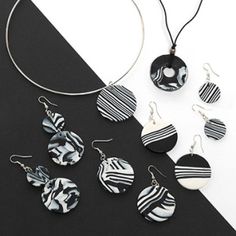 black and white jewelry set with circular pendant, earrings and necklace on top of table