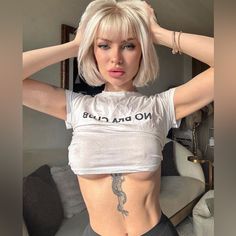 a woman with short blonde hair and tattoos on her stomach is posing for the camera