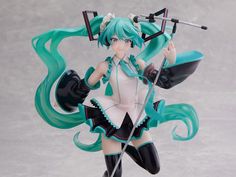 an anime figurine is posed in front of a gray background with long green hair